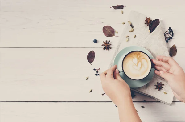 Woman has autumn cappuccino coffee, top view on white wood — Stock Photo, Image