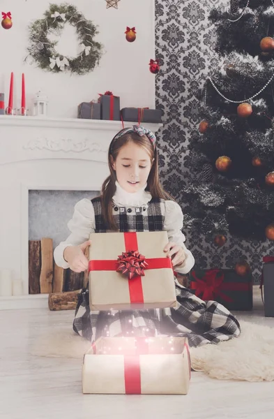 Menina bonita desembrulhando presentes de Natal — Fotografia de Stock