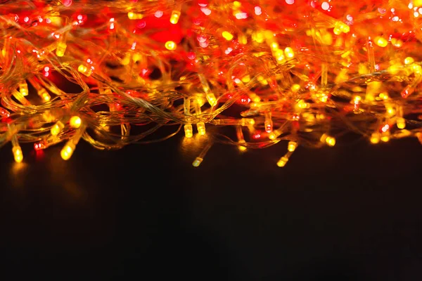 Natal vermelho e amarelo luzes fronteira na luz de fundo de madeira — Fotografia de Stock