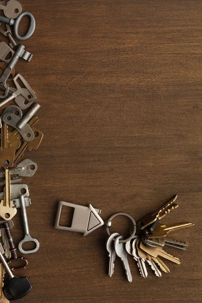 Bunch of keys with house trinklet on wooden table