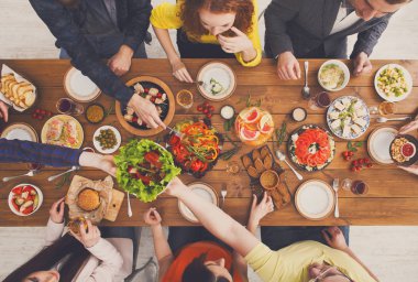 İnsanlar yemek ve sağlıklı yemekler, hizmet tablo yemeğinde paylaşmak