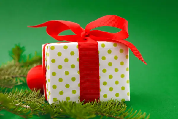 Karácsonyi ünnep becsomagolt ajándékdoboz, világos piros háttérben — Stock Fotó