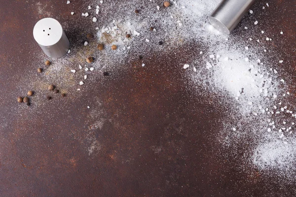 Spridda salt och peppar på mörk bakgrund — Stockfoto