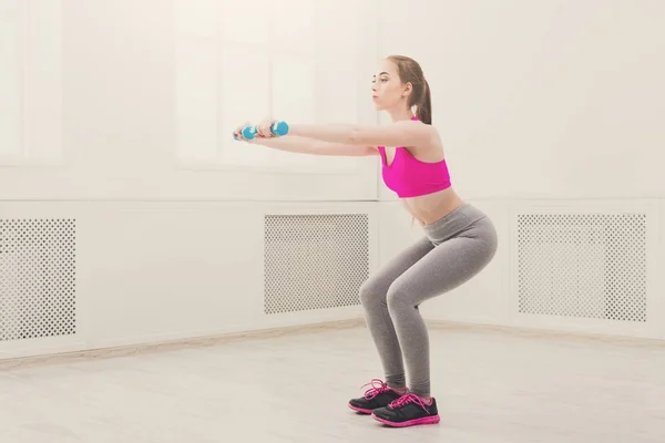 Fitness-Frau macht Kniebeuge auf weißem Hintergrund — Stockfoto