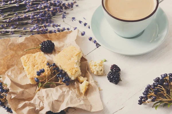 Beyaz ahşap üzerine sütlü kahve ve çiçek kompozisyon