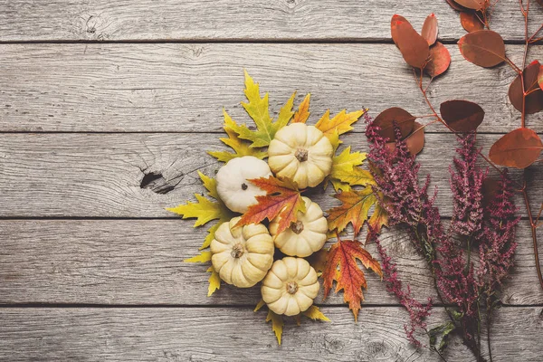 Herbst-Stillleben mit Kürbissen und trockenen Blättern auf Holzrücken — Stockfoto