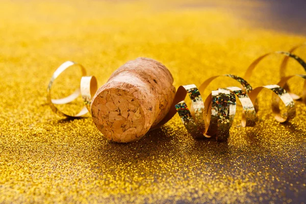 Champagne cork and serpentine on glitter backdrop