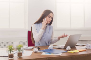 Ciddi iş kadını telefonda konuşurken iş başında