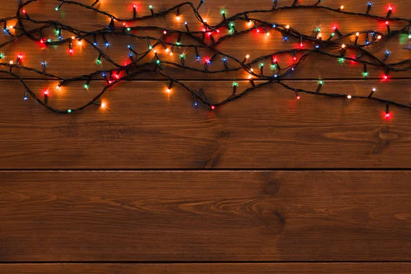 Kerstverlichting grens op houten achtergrond — Stockfoto