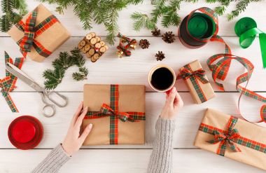 Eller, dağınık masa artalanını Xmas hediye paketleme