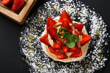 Anna Pavlova pasta siyah arka plan üzerine çilek ile