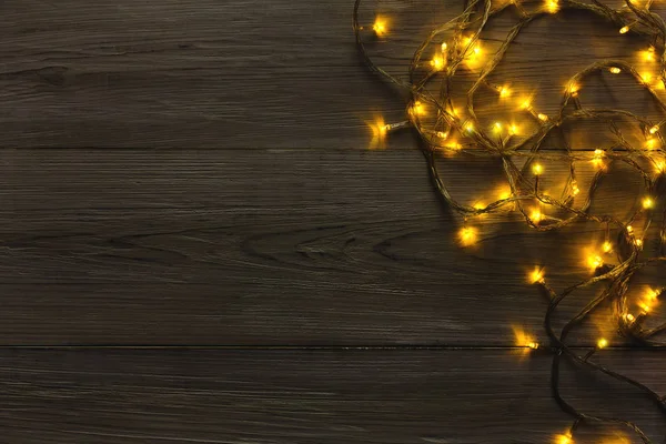Julbelysning gränsar på grå trä bakgrund — Stockfoto