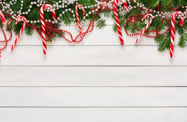 Weihnachten Hintergrund mit Bonbons und Tannenbaumrand auf Holz — Stockfoto