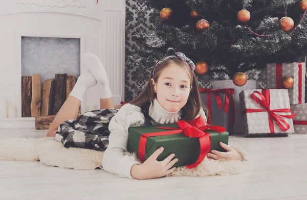 Hermosa niña y regalo de Navidad en el interior —  Fotos de Stock