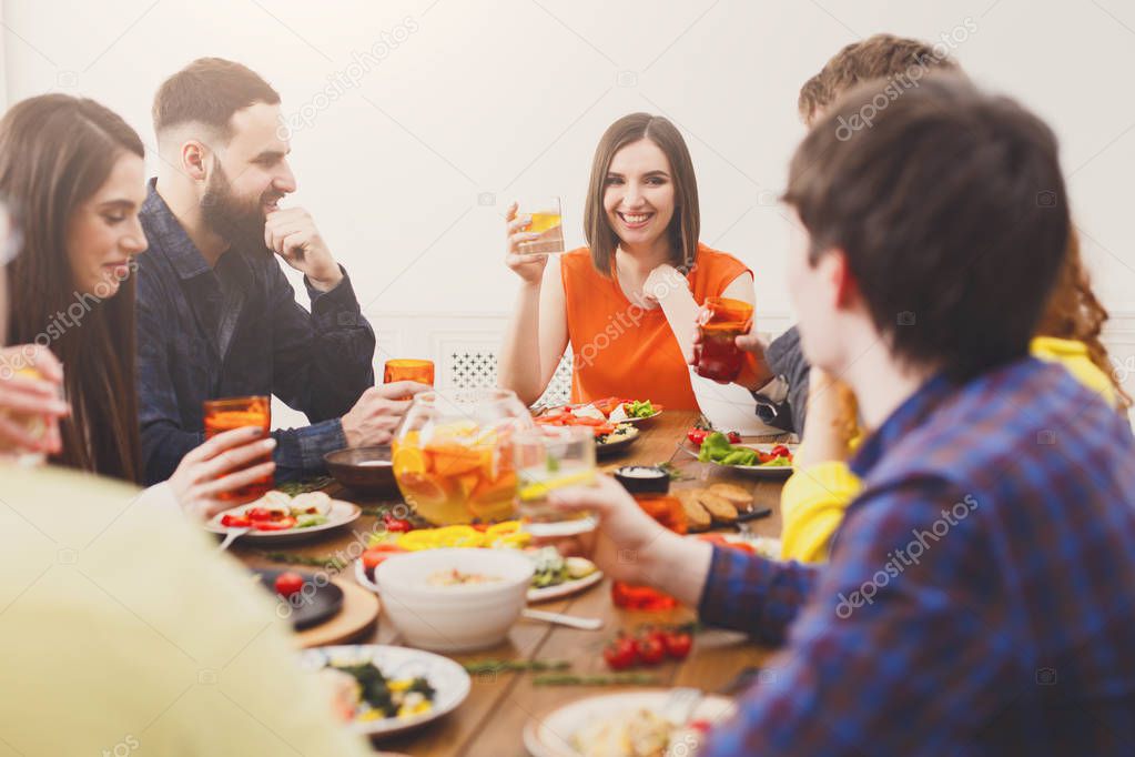 Group of happy young people at festive table dinner party