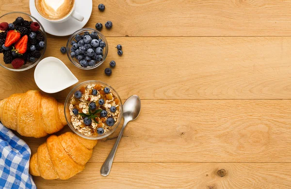 Continental breakfast with croissants and berries on natural wood — Stock Photo, Image