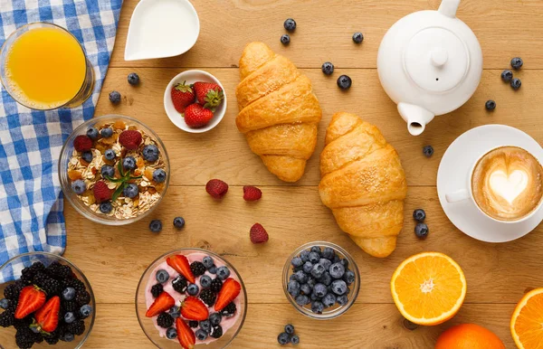 Kontinental frukost med croissanter och bär på trä — Stockfoto