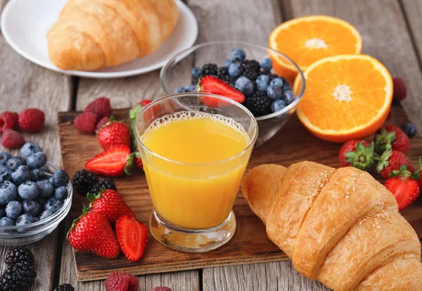 Свежие круассаны и апельсиновый сок для утренней еды — стоковое фото