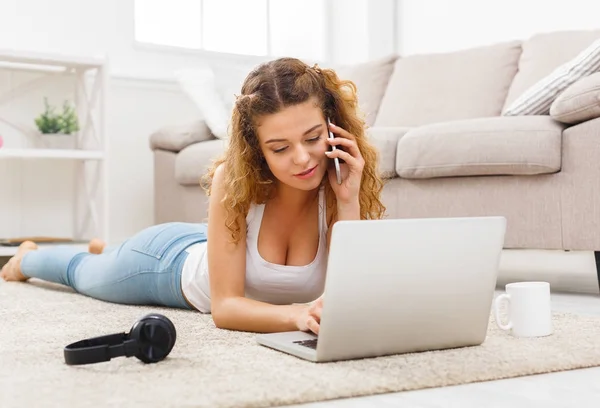 Студентська дівчина використовує ноутбук і розмовляє на мобільному — стокове фото