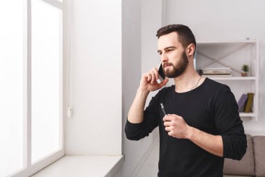 Cep telefonu ve vaping konuşan ciddi adam