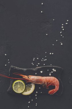 Siyah arka plan üzerine limon ve tuz ile karides
