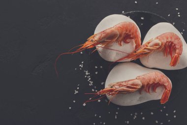 Siyah arka plan üzerine beyaz taşlarla karides