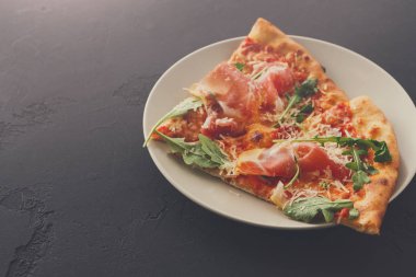 Dilimlenmiş pizza jambon ve roket salata ile