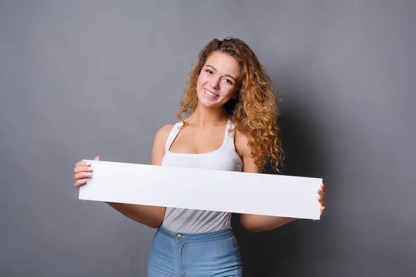Молода жінка тримає порожній білий банер — стокове фото
