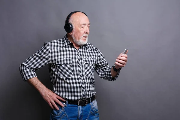 Hombre mayor escuchando música con auriculares — Foto de Stock