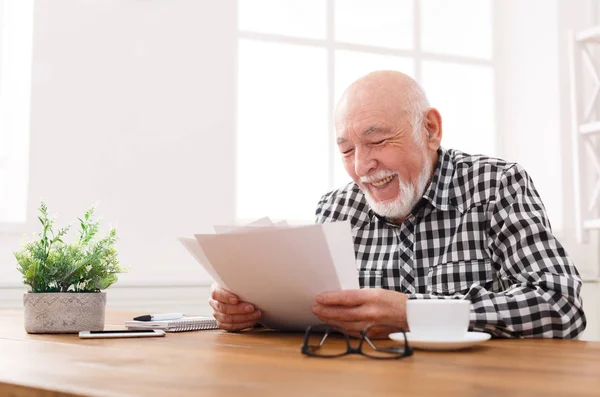 Fröhlicher älterer Mann sucht Fotos, kopiert Raum — Stockfoto