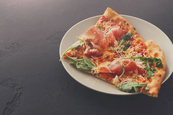 Dilimlenmiş pizza jambon ve roket salata ile