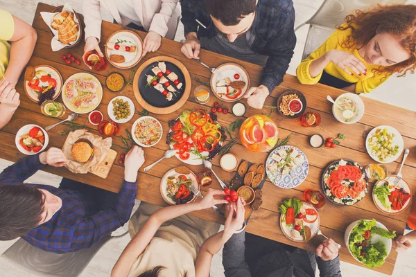 Mensen eten gezonde maaltijden op tafel geserveerd diner — Stockfoto