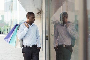 Siyah işadamı alışveriş çantaları taşırken