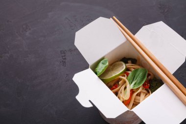 Gri arka plan üzerinde teslim kutusundaki Asya gıda