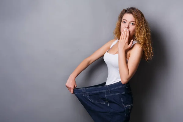 Mulher vestindo jeans tamanho muito maior — Fotografia de Stock