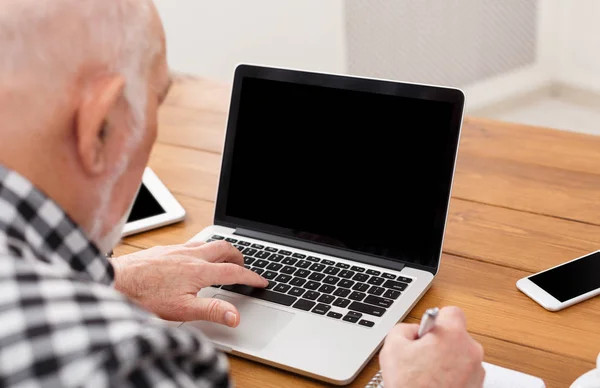Ανώτερος άνθρωπος χρησιμοποιώντας laptop με κενή οθόνη κοροϊδεύω — Φωτογραφία Αρχείου