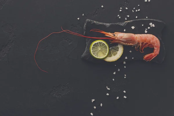 Camarones con sal y limón sobre fondo negro — Foto de Stock