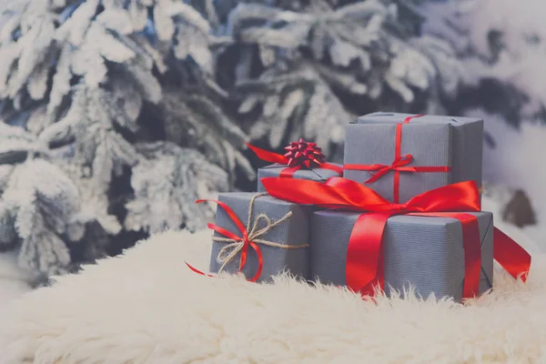 Presentes de Natal em fundo de abeto borrado, conceito de férias — Fotografia de Stock