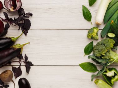 Beyaz ahşap üzerine çeşitli yeşil ve mor sebze kenarlık