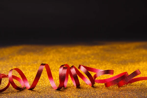 Kręcone czerwony serpentyn na tle świecidełka — Zdjęcie stockowe