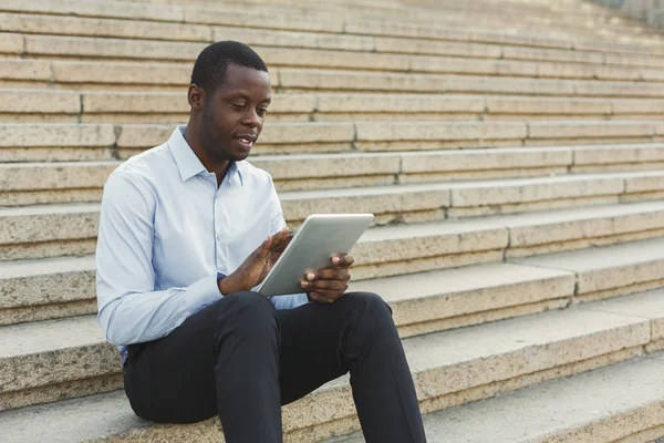 Empresário afro-americano trabalhando com tablet ao ar livre — Fotografia de Stock