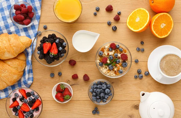 Continental breakfast with croissants and berries on natural wood — Stock Photo, Image