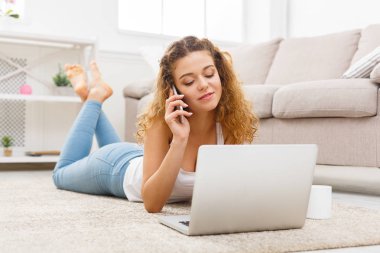 Dizüstü bilgisayar kullanarak ve cep telefonunuza konuşan öğrenci kız