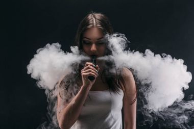 Genç kadın vaping e-sigara dumanlı siyah