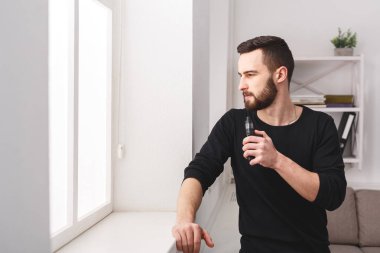 Vaping e-sigara pencerede evde genç adam