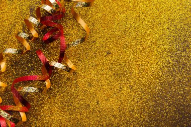 Glitter arka plan üzerinde kırmızı ve altın serpantin