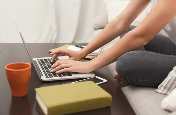 Unerkennbares Mädchen mit Laptop auf dem Sofa — Stockfoto