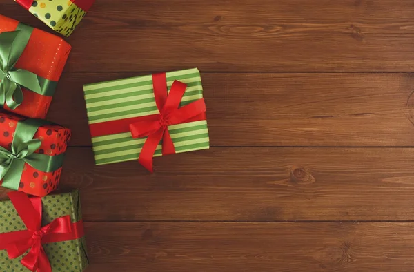 Ahşap arka plan üzerinde renkli Noel mevcut kutuları