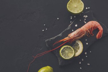 Siyah arka plan üzerine limon ve tuz ile karides