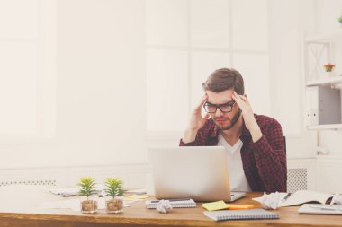 Genç işadamı modern beyaz ofis içinde laptop ile vurguladı